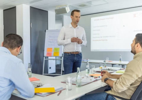 Seminarteilnehmende an einem Tisch mit Seminarleiter